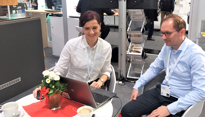 Anna Pianka zeigt einem Interessenten am Laptop Optimierungspotenzial für seine Webseite auf