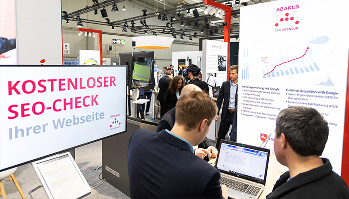 ABAKUS SEO Philipp Ehring und Hannover Messe Fachbesucher beim SEO-Website-Check am Laptop